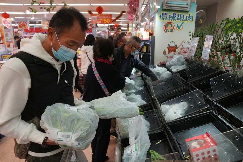 Customers wearing face masks shop at a market, following the outbreak of the coronavirus disease (COVID-19), at Sha Tin district, in Hong Kong, China, February 7, 2022. REUTERS/Lam Yik