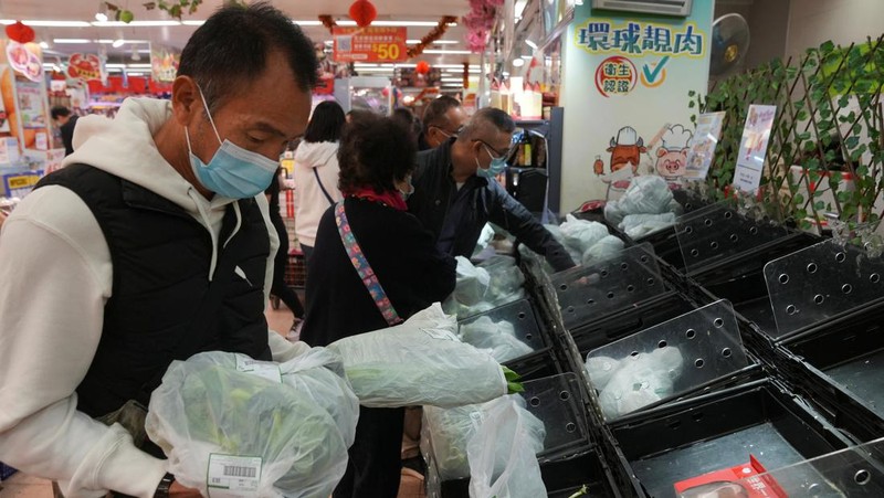 Customers wearing face masks shop at a market, following the outbreak of the coronavirus disease (COVID-19), at Sha Tin district, in Hong Kong, China, February 7, 2022. REUTERS/Lam Yik
