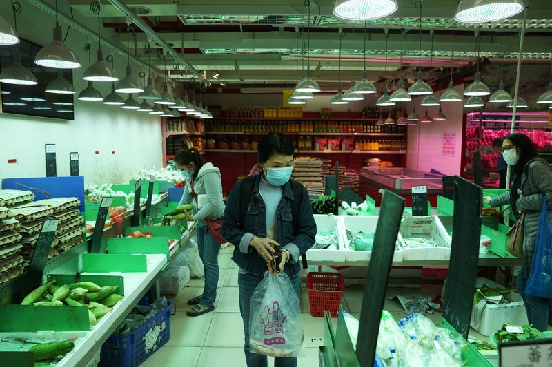 Customers wearing face masks shop at a market, following the outbreak of the coronavirus disease (COVID-19), at Sha Tin district, in Hong Kong, China, February 7, 2022. REUTERS/Lam Yik