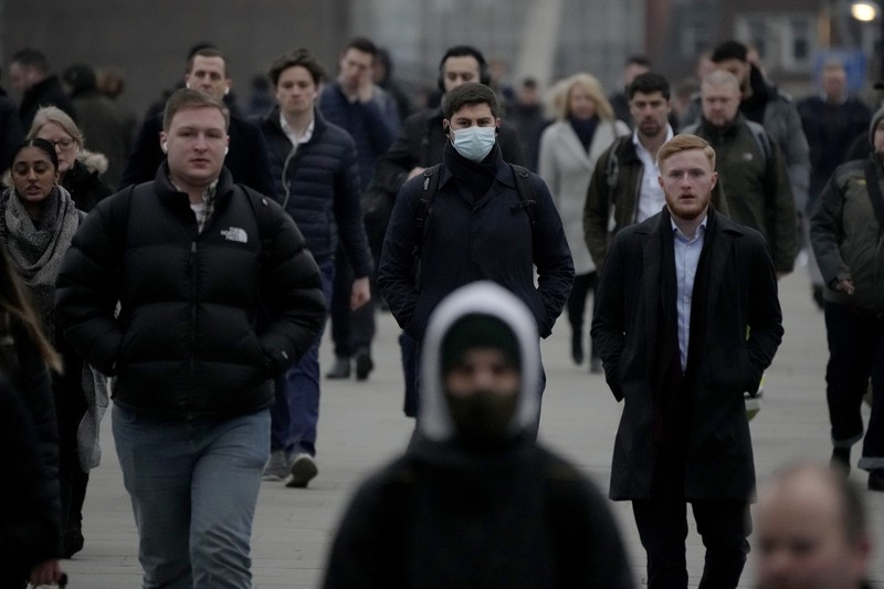 Virus Britain Outbreak Workers walk over London Bridge towards the City of London financial district during the morning rush hour, in London, Monday, Jan. 24, 2022. The British government have asked people to return to working in offices starting Monday as they ease coronavirus restrictions. (AP Photo/Matt Dunham)