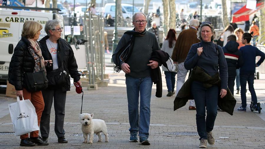 People not wearing face masks walk in Saint-Jean-de-Luz southwestern France, Wednesday, Fev.2, 2022. England, France, Ireland, the Netherlands and several Nordic countries have taken steps to end or loosen their restrictions. Step by step, many countries are easing their COVID-19 restrictions amid hopes the omicron wave may have passed its peak. (AP Photo/Bob Edme)