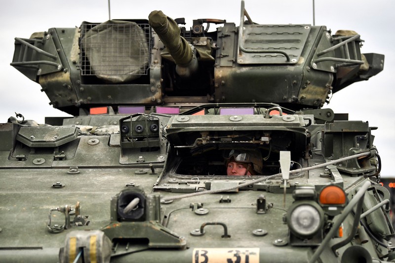 A soldier of the U.S. 2nd Cavalry Regiment stands in a combat vehicle as gear is prepared for deployment to Romania at Rose Barracks in Vilseck, Germany, February 9, 2022.  REUTERS/Lukas Barth