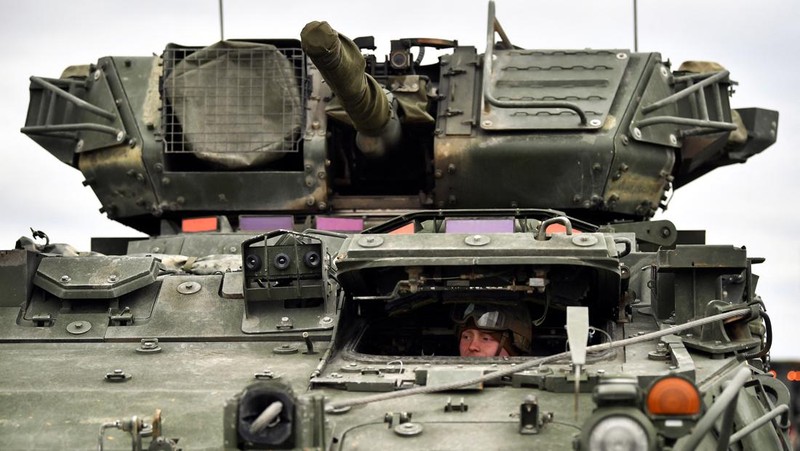 A soldier of the U.S. 2nd Cavalry Regiment stands in a combat vehicle as gear is prepared for deployment to Romania at Rose Barracks in Vilseck, Germany, February 9, 2022.  REUTERS/Lukas Barth