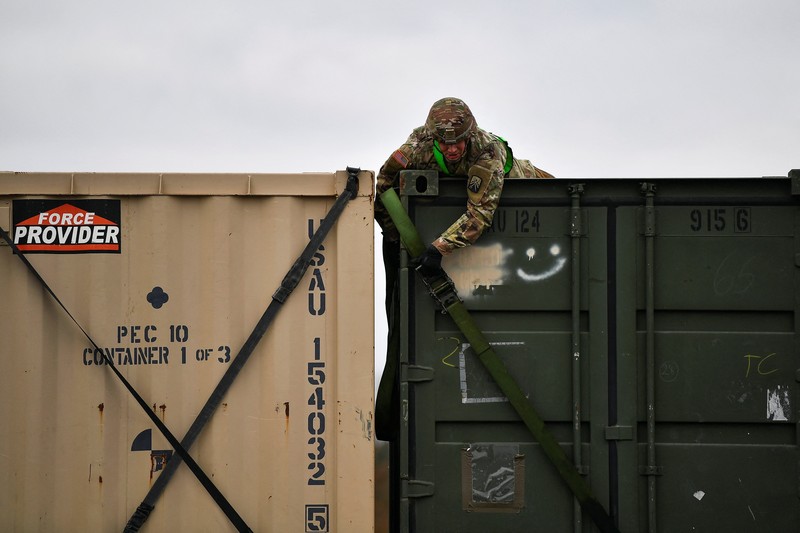 A soldier of the U.S. 2nd Cavalry Regiment stands in a combat vehicle as gear is prepared for deployment to Romania at Rose Barracks in Vilseck, Germany, February 9, 2022.  REUTERS/Lukas Barth