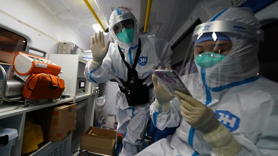 A medical worker waves while transporting Associated Press photographer Matt Slocum after a positive coronavirus test at the 2022 Winter Olympics, Wednesday, Feb. 9, 2022, in Beijing. Slocum was monitored for hours before testing negative and being cleared to go back to work. (AP Photo/Matt Slocum)