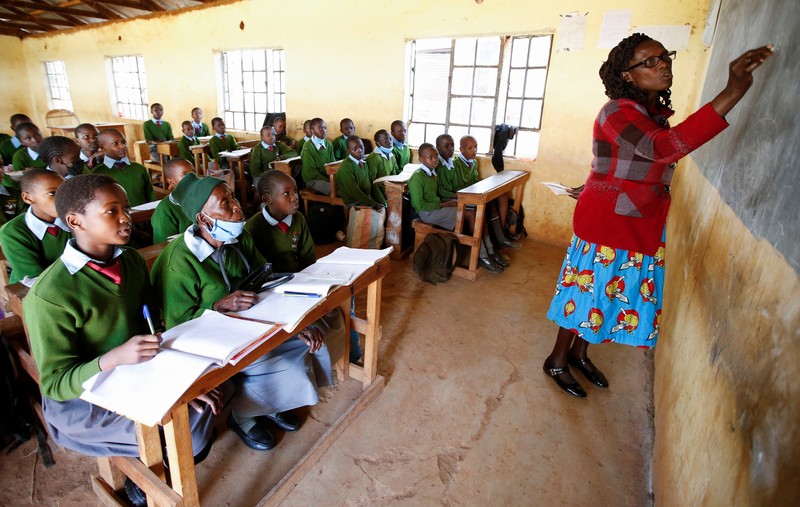 KENYA-EDUCATION/GRANDMA Priscilla Sitienei, a 98-year-old primary school student in grade six, is helped to do an assignment by her classmate at the Leaders Vision Preparatory School in Ndalat village of Nandi County, Kenya January 25, 2022. Picture taken January 25, 2022. REUTERS/Monicah Mwangi
