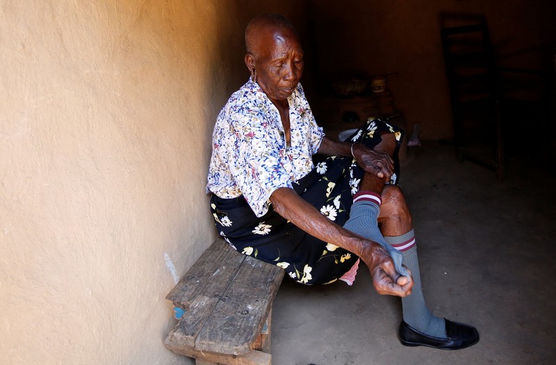 Priscilla Sitienei, a 98-year-old primary school student in grade six, is helped to do an assignment by her classmate at the Leaders Vision Preparatory School in Ndalat village of Nandi County, Kenya January 25, 2022. Picture taken January 25, 2022. REUTERS/Monicah Mwangi