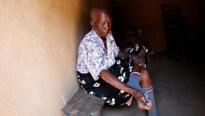 Priscilla Sitienei, a 98-year-old primary school student in grade six, is helped to do an assignment by her classmate at the Leaders Vision Preparatory School in Ndalat village of Nandi County, Kenya January 25, 2022. Picture taken January 25, 2022. REUTERS/Monicah Mwangi