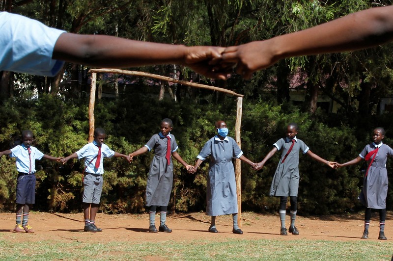 Priscilla Sitienei, a 98-year-old primary school student in grade six, is helped to do an assignment by her classmate at the Leaders Vision Preparatory School in Ndalat village of Nandi County, Kenya January 25, 2022. Picture taken January 25, 2022. REUTERS/Monicah Mwangi
