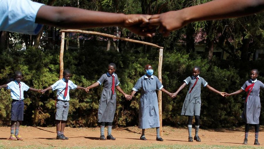 Priscilla Sitienei, a 98-year-old primary school student in grade six, is helped to do an assignment by her classmate at the Leaders Vision Preparatory School in Ndalat village of Nandi County, Kenya January 25, 2022. Picture taken January 25, 2022. REUTERS/Monicah Mwangi