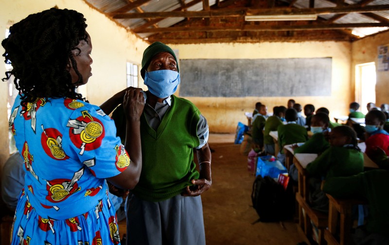 KENYA-EDUCATION/GRANDMA Priscilla Sitienei, a 98-year-old primary school student in grade six, is helped to do an assignment by her classmate at the Leaders Vision Preparatory School in Ndalat village of Nandi County, Kenya January 25, 2022. Picture taken January 25, 2022. REUTERS/Monicah Mwangi