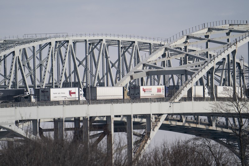Trucks heading to Canada are stuck in heavy traffic after they were diverted to the Blue Water Bridge in Port Huron, Mich., Wednesday, Feb. 9, 2022, after the Ambassador Bridge was closed due to Canadian anti-vaccine protests. (Mandi Wright/Detroit Free Press via AP)