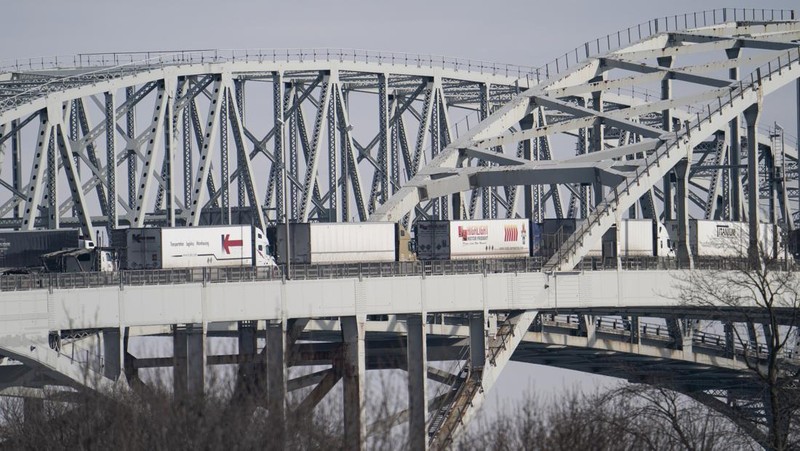 Trucks heading to Canada are stuck in heavy traffic after they were diverted to the Blue Water Bridge in Port Huron, Mich., Wednesday, Feb. 9, 2022, after the Ambassador Bridge was closed due to Canadian anti-vaccine protests. (Mandi Wright/Detroit Free Press via AP)
