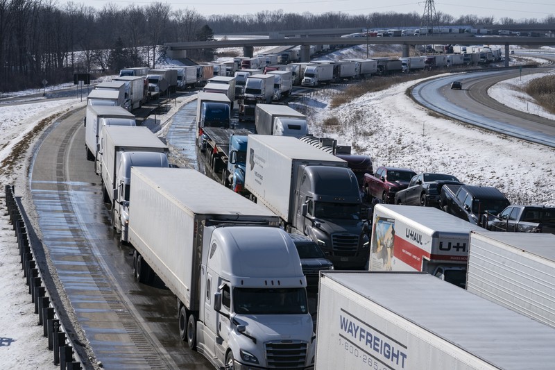 Trucks heading to Canada are stuck in heavy traffic after they were diverted to the Blue Water Bridge in Port Huron, Mich., Wednesday, Feb. 9, 2022, after the Ambassador Bridge was closed due to Canadian anti-vaccine protests. (Mandi Wright/Detroit Free Press via AP)