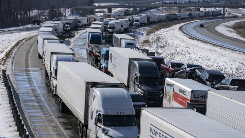 Trucks heading to Canada are stuck in heavy traffic after they were diverted to the Blue Water Bridge in Port Huron, Mich., Wednesday, Feb. 9, 2022, after the Ambassador Bridge was closed due to Canadian anti-vaccine protests. (Mandi Wright/Detroit Free Press via AP)