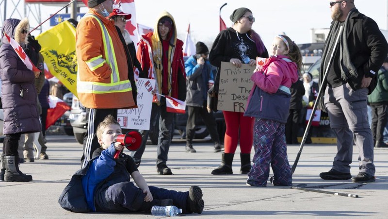 Trucks heading to Canada are stuck in heavy traffic after they were diverted to the Blue Water Bridge in Port Huron, Mich., Wednesday, Feb. 9, 2022, after the Ambassador Bridge was closed due to Canadian anti-vaccine protests. (Mandi Wright/Detroit Free Press via AP)