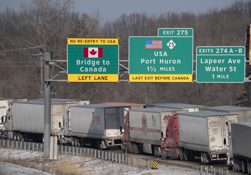 Trucks heading to Canada are stuck in heavy traffic after they were diverted to the Blue Water Bridge in Port Huron, Mich., Wednesday, Feb. 9, 2022, after the Ambassador Bridge was closed due to Canadian anti-vaccine protests. (Mandi Wright/Detroit Free Press via AP)