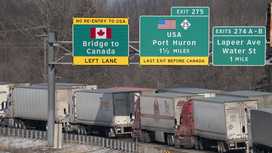 Trucks heading to Canada are stuck in heavy traffic after they were diverted to the Blue Water Bridge in Port Huron, Mich., Wednesday, Feb. 9, 2022, after the Ambassador Bridge was closed due to Canadian anti-vaccine protests. (Mandi Wright/Detroit Free Press via AP)