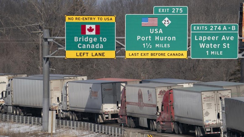 Trucks heading to Canada are stuck in heavy traffic after they were diverted to the Blue Water Bridge in Port Huron, Mich., Wednesday, Feb. 9, 2022, after the Ambassador Bridge was closed due to Canadian anti-vaccine protests. (Mandi Wright/Detroit Free Press via AP)