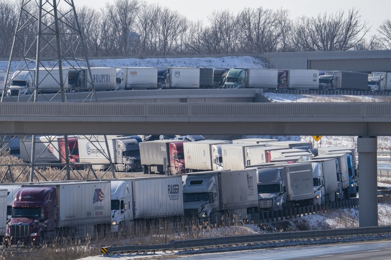 Trucks heading to Canada are stuck in heavy traffic after they were diverted to the Blue Water Bridge in Port Huron, Mich., Wednesday, Feb. 9, 2022, after the Ambassador Bridge was closed due to Canadian anti-vaccine protests. (Mandi Wright/Detroit Free Press via AP)