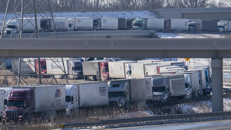 Trucks heading to Canada are stuck in heavy traffic after they were diverted to the Blue Water Bridge in Port Huron, Mich., Wednesday, Feb. 9, 2022, after the Ambassador Bridge was closed due to Canadian anti-vaccine protests. (Mandi Wright/Detroit Free Press via AP)