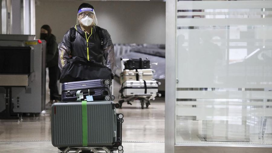 Airport officials check documents of foreign passengers at a counter as they arrive at Manila's International Airport, Philippines Thursday, Feb. 10, 2022. The Philippines lifted a nearly 2-year ban on foreign travelers Thursday in a lifesaving boost for its tourism and related industries as an omicron-fueled surge eases. (AP Photo/Basilio Sepe)