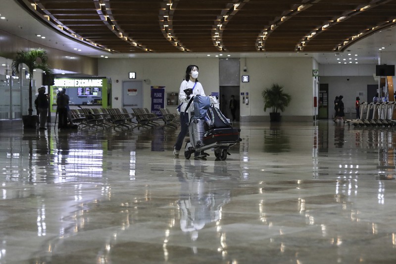Airport officials check documents of foreign passengers at a counter as they arrive at Manila's International Airport, Philippines Thursday, Feb. 10, 2022. The Philippines lifted a nearly 2-year ban on foreign travelers Thursday in a lifesaving boost for its tourism and related industries as an omicron-fueled surge eases. (AP Photo/Basilio Sepe)