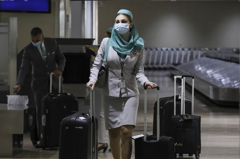 Airport officials check documents of foreign passengers at a counter as they arrive at Manila's International Airport, Philippines Thursday, Feb. 10, 2022. The Philippines lifted a nearly 2-year ban on foreign travelers Thursday in a lifesaving boost for its tourism and related industries as an omicron-fueled surge eases. (AP Photo/Basilio Sepe)