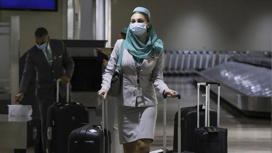 Airport officials check documents of foreign passengers at a counter as they arrive at Manila's International Airport, Philippines Thursday, Feb. 10, 2022. The Philippines lifted a nearly 2-year ban on foreign travelers Thursday in a lifesaving boost for its tourism and related industries as an omicron-fueled surge eases. (AP Photo/Basilio Sepe)