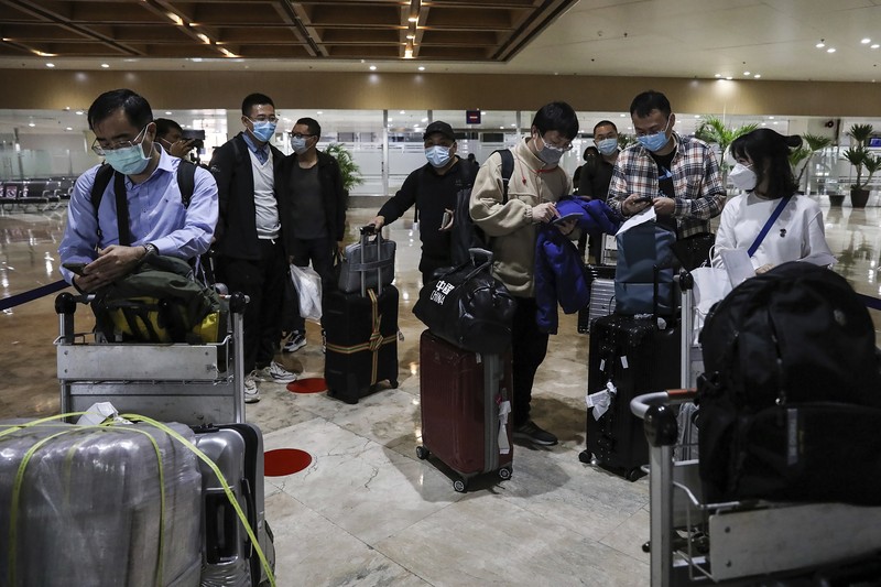 Virus Outbreak Philippines Airport officials check documents of foreign passengers at a counter as they arrive at Manila's International Airport, Philippines Thursday, Feb. 10, 2022. The Philippines lifted a nearly 2-year ban on foreign travelers Thursday in a lifesaving boost for its tourism and related industries as an omicron-fueled surge eases. (AP Photo/Basilio Sepe)