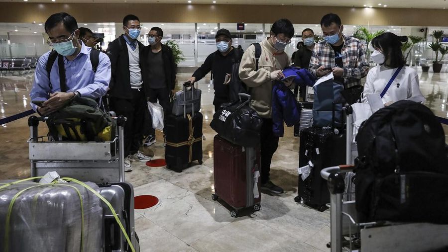 Airport officials check documents of foreign passengers at a counter as they arrive at Manila's International Airport, Philippines Thursday, Feb. 10, 2022. The Philippines lifted a nearly 2-year ban on foreign travelers Thursday in a lifesaving boost for its tourism and related industries as an omicron-fueled surge eases. (AP Photo/Basilio Sepe)