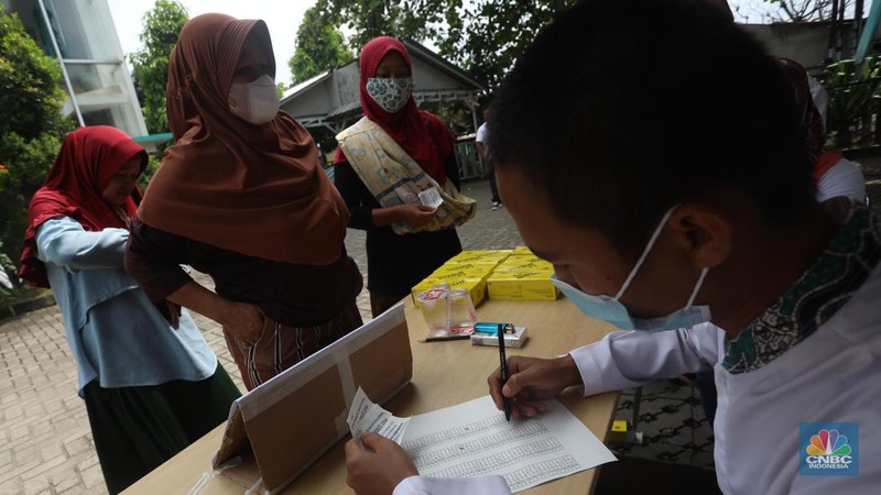 Warga menukarkan kupon untuk membeli minyak goreng saat pasar murah di Kantor Kelurahan Lenkong Karya, Serpong, Tangerang Selatan, Jumat (11/2/2022). (CNBC Indonesia/Andrean Kristianto)