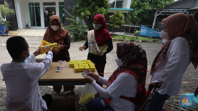 Warga menukarkan kupon untuk membeli minyak goreng saat pasar murah di Kantor Kelurahan Lenkong Karya, Serpong, Tangerang Selatan, Jumat (11/2/2022). (CNBC Indonesia/Andrean Kristianto)
