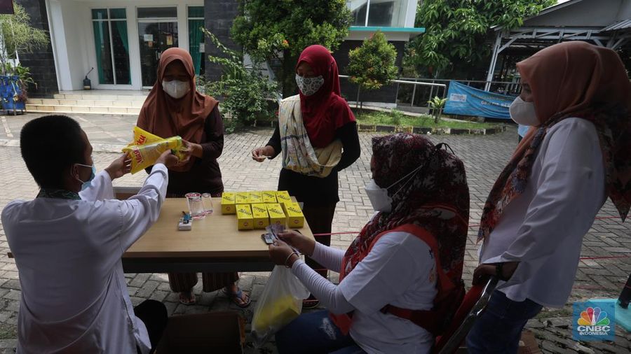 Warga menukarkan kupon untuk membeli minyak goreng saat pasar murah di Kantor Kelurahan Lenkong Karya, Serpong, Tangerang Selatan, Jumat (11/2/2022). (CNBC Indonesia/Andrean Kristianto)