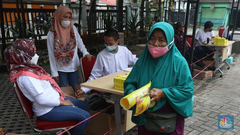 Warga menukarkan kupon untuk membeli minyak goreng saat pasar murah di Kantor Kelurahan Lenkong Karya, Serpong, Tangerang Selatan, Jumat (11/2/2022). (CNBC Indonesia/Andrean Kristianto)
