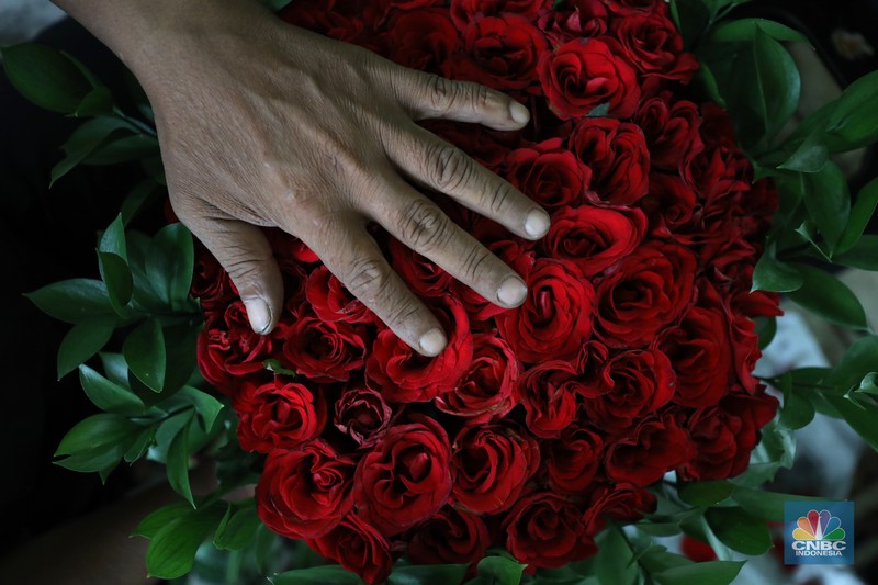 Pekerja menyelesaikan rangkaian bunga valentine di pasar bunga Rawabelong, Jakarta, Senin (14/2/2022). Lonjakan kasus Covid-19 membuat pedagang bunga hias mengalami penurunan 30 persen dibandingkan dengan tahun lalu.  (CNBC Indonesia/ Tri Susilo)