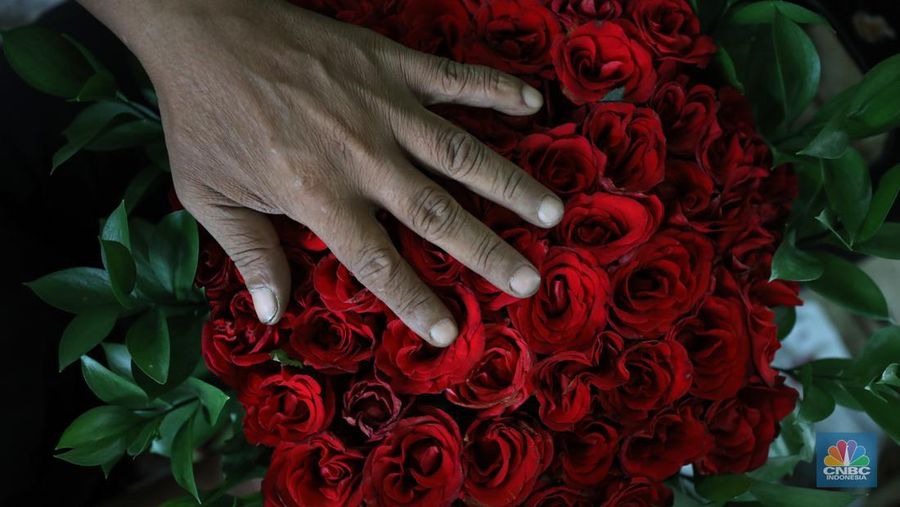 Pekerja menyelesaikan rangkaian bunga valentine di pasar bunga Rawabelong, Jakarta, Senin (14/2/2022). (CNBC Indonesia/ Tri Susilo)