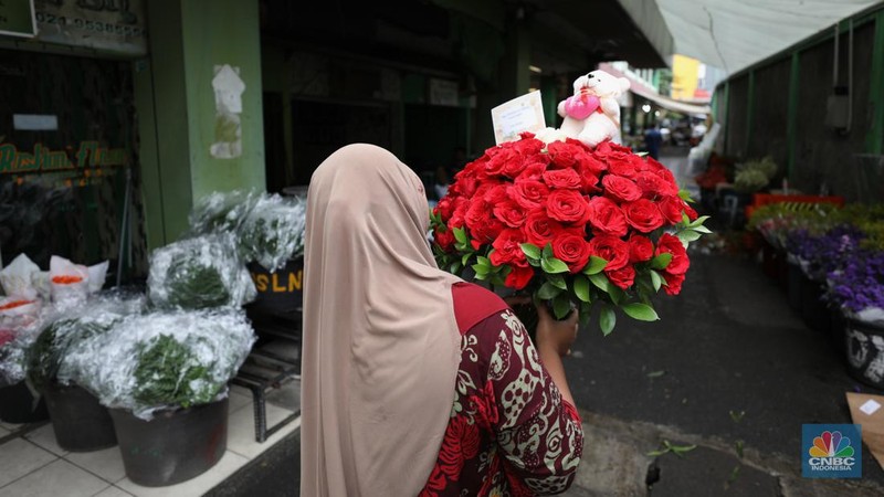 Pekerja menyelesaikan rangkaian bunga valentine di pasar bunga Rawabelong, Jakarta, Senin (14/2/2022). Lonjakan kasus Covid-19 membuat pedagang bunga hias mengalami penurunan 30 persen dibandingkan dengan tahun lalu.  (CNBC Indonesia/ Tri Susilo)