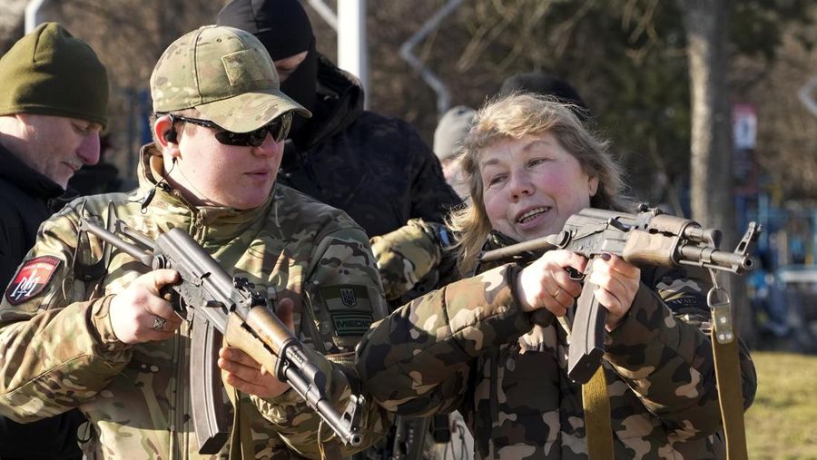 Seorang instruktur menunjukkan kepada seorang wanita cara menggunakan senapan serbu Kalashnikov, saat latihan militer untuk warga sipil oleh kelompok sayap kanan Ukraina di Kyiv, Ukraina, Minggu (13/2/2022). Rusia membantah berniat menyerang tetapi telah mengumpulkan lebih dari 100.000 tentara dekat perbatasan Ukraina dan telah mengirim pasukan untuk latihan di negara tetangga Belarusia, mengelilingi Ukraina di tiga sisi. Para pejabat AS mengatakan penumpukan senjata Rusia telah mencapai titik di mana ia dapat menyerang dalam waktu singkat. (AP/Efrem Lukatsky)