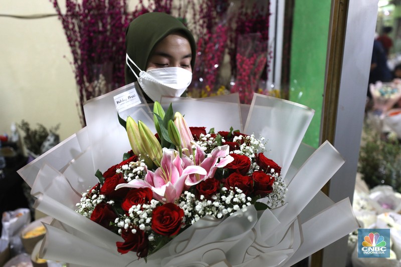 Penjualan Bunga Saat Valentine Pekerja menyelesaikan rangkaian bunga valentine di pasar bunga Rawabelong, Jakarta, Senin (14/2/2022). Lonjakan kasus Covid-19 membuat pedagang bunga hias mengalami penurunan 30 persen dibandingkan dengan tahun lalu. (CNBC Indonesia/ Tri Susilo)