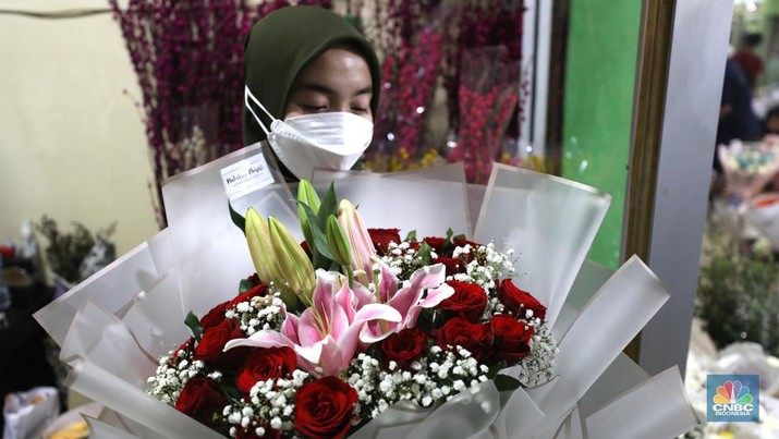 Pekerja menyelesaikan rangkaian bunga valentine di pasar bunga Rawabelong, Jakarta, Senin (14/2/2022). Lonjakan kasus Covid-19 membuat pedagang bunga hias mengalami penurunan 30 persen dibandingkan dengan tahun lalu.  (CNBC Indonesia/ Tri Susilo)