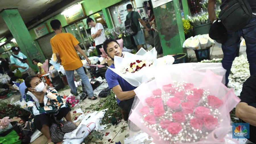 Pekerja menyelesaikan rangkaian bunga valentine di pasar bunga Rawabelong, Jakarta, Senin (14/2/2022). Lonjakan kasus Covid-19 membuat pedagang bunga hias mengalami penurunan 30 persen dibandingkan dengan tahun lalu.  (CNBC Indonesia/ Tri Susilo)