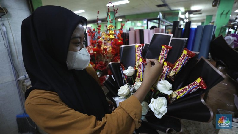 Pekerja menyelesaikan rangkaian bunga valentine di pasar bunga Rawabelong, Jakarta, Senin (14/2/2022). Lonjakan kasus Covid-19 membuat pedagang bunga hias mengalami penurunan 30 persen dibandingkan dengan tahun lalu.  (CNBC Indonesia/ Tri Susilo)