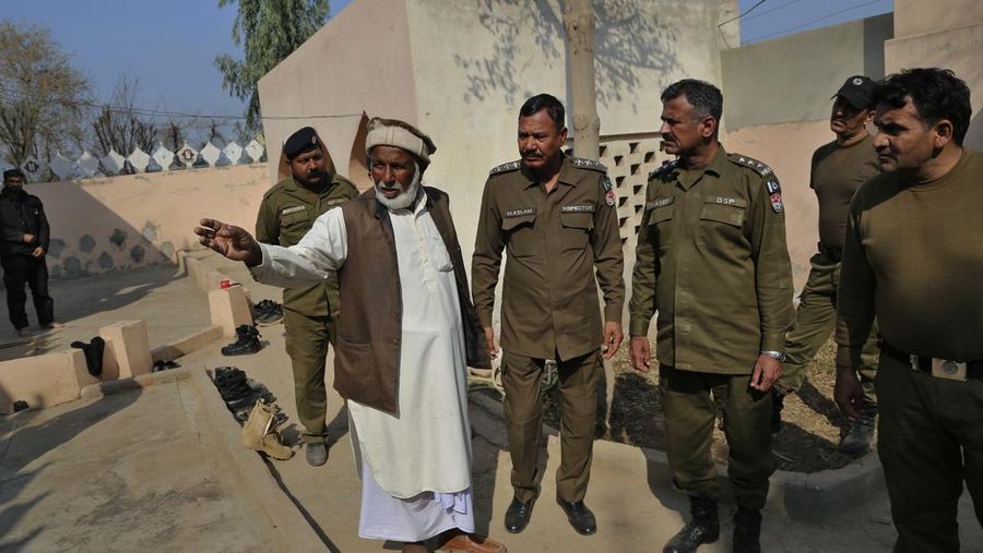 Petugas kepolisian berjaga di sebuah masjid, di mana massa yang marah melempari Mushtaq Ahmed (41) dengan batu hingga tewas karena diduga menodai Alquran, di Tulamba, sebuah desa terpencil di distrik Khanewal di Pakistan timur, Minggu (13/2/2022). Serangan massa terhadap orang-orang yang dituduh melakukan penistaan adalah hal biasa di negara Islam konservatif ini di mana penistaan dapat dihukum mati. (AP Photo/Asim Tanveer)