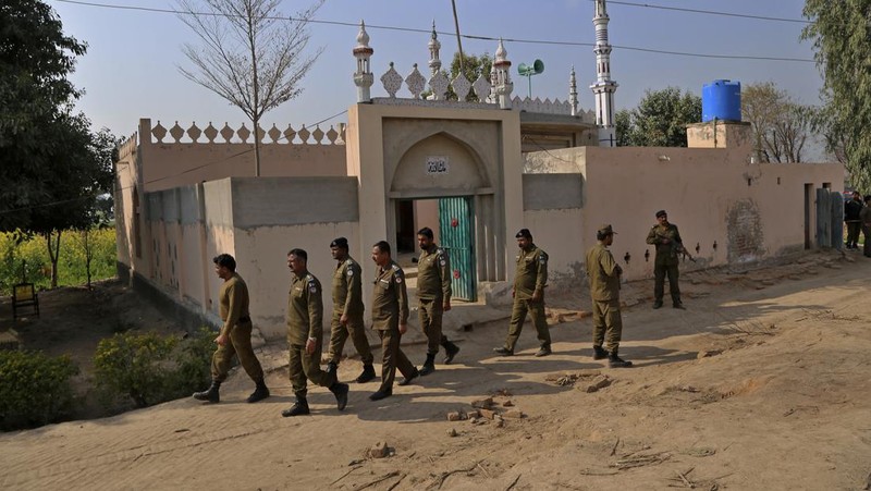 Petugas kepolisian berjaga di sebuah masjid, di mana massa yang marah melempari Mushtaq Ahmed (41) dengan batu hingga tewas karena diduga menodai Alquran, di Tulamba, sebuah desa terpencil di distrik Khanewal di Pakistan timur, Minggu (13/2/2022). Serangan massa terhadap orang-orang yang dituduh melakukan penistaan adalah hal biasa di negara Islam konservatif ini di mana penistaan dapat dihukum mati. (AP Photo/Asim Tanveer)