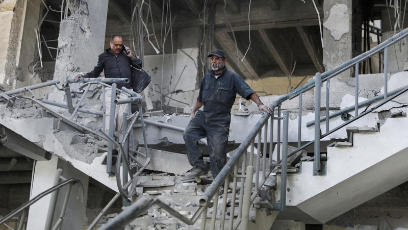 Seorang penjaga keamanan memeriksa lokasi serangan udara koalisi militer pimpinan Arab Saudi di sebuah stasiun telekomunikasi di Sanaa, Yaman, Senin (14/2/2022). (REUTERS/Khaled Abdullah)