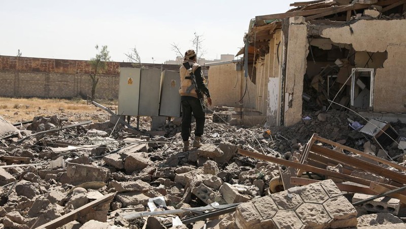 Seorang penjaga keamanan memeriksa lokasi serangan udara koalisi militer pimpinan Arab Saudi di sebuah stasiun telekomunikasi di Sanaa, Yaman, Senin (14/2/2022). (REUTERS/Khaled Abdullah)