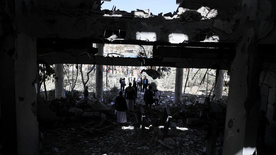 Seorang penjaga keamanan memeriksa lokasi serangan udara koalisi militer pimpinan Arab Saudi di sebuah stasiun telekomunikasi di Sanaa, Yaman, Senin (14/2/2022). (REUTERS/Khaled Abdullah)