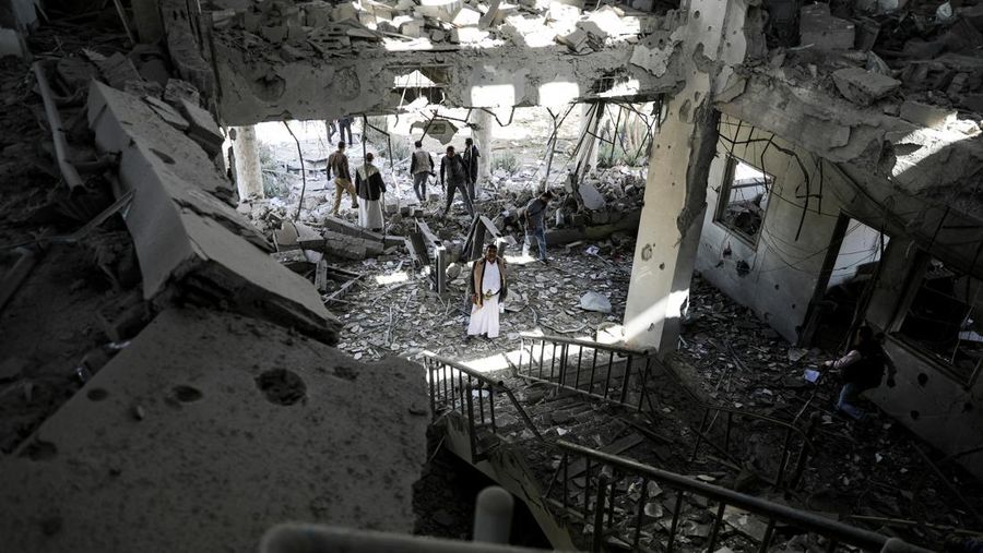 Penjaga keamanan dan wartawan memeriksa lokasi serangan udara koalisi militer pimpinan Arab Saudi di sebuah stasiun telekomunikasi di Sanaa, Yaman, Senin (14/2/2022). (REUTERS/Khaled Abdullah)