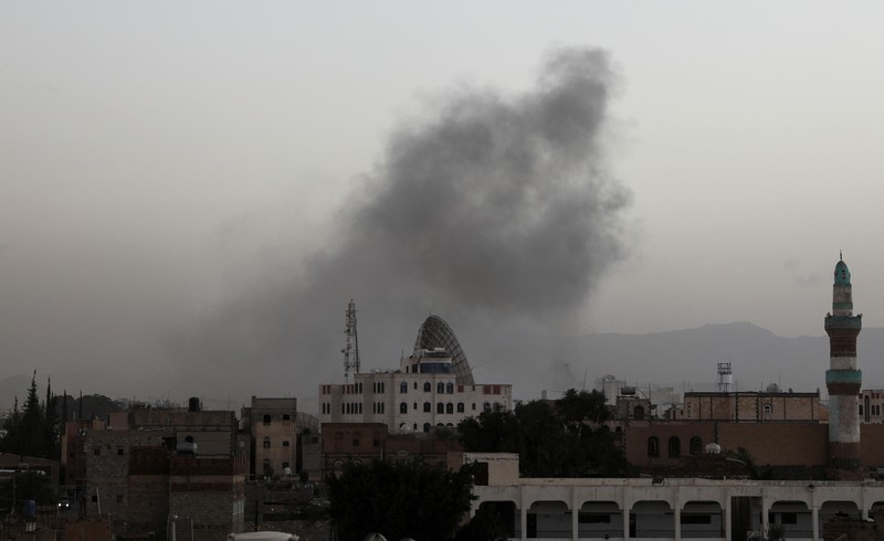 Seorang penjaga keamanan memeriksa lokasi serangan udara koalisi militer pimpinan Arab Saudi di sebuah stasiun telekomunikasi di Sanaa, Yaman, Senin (14/2/2022). (REUTERS/Khaled Abdullah)